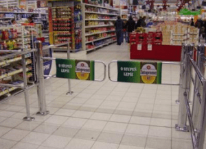 reklamní polepy na značku piva na vstupních turniketech v hypermarketu