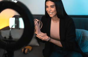 influencerka prezentující botu na podpatku před kamerou v mobilu